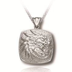 This cushion Cremation Jewelry portrays the mythical dragon; a representation of wisdom and longevity. This outstanding sterling silver cremation pendant comes with an 18", 20" or 24" Italian Sterling Silver Heavy Franco style Chain measuring 2mm thick, a very attractive Jewelry Display box and a Sterling Silver Scoop to assist in filling your Cremation Jewelry. Dimensions are approximately 0.71"H x 0.71"W x 0.24"D Silver Dragon Design Jewelry For Formal Occasions, Silver Jewelry With Dragon Design For Formal Occasions, Formal Silver Jewelry With Dragon Design, Silver Dragon Design Jewelry For Anniversary, Carved White Gold Necklaces As Gift, Silver Carved Rectangular Jewelry, Carved Silver Rectangular Jewelry, Silver Rectangular Carved Jewelry, Carved Rectangular Silver Jewelry