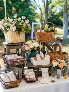 a table topped with lots of baskets filled with flowers and other items on top of it