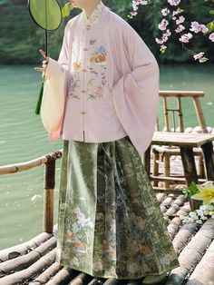 The timeless beauty and exquisite craftsmanship of the Ming Dynasty comes alive in the Ya Chi 鸭池 Duck Pond Ming Dynasty Set, perfect for those who appreciate the delicate artistry and serene aesthetics. The soft pink Fangling Banxiu 方领半袖 (square collar half sleeve jacket) is adorned with intricate embroidery, depicting ducks gracefully gliding within a tranquil pond surrounded by delicate camellias and Chinese style rocks. The half sleeves and classic square collar allow the shirt beneath to pee Modern Hanfu, Spring Fairy, Duck Pond, China Dress, New Chinese Style, New Chinese, Plus Size Wedding, Sleeve Jacket