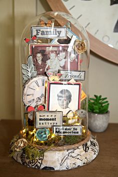 a glass dome with pictures and magnets on it sitting on a table in front of a clock