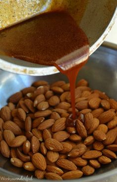 almonds being poured into a metal bowl