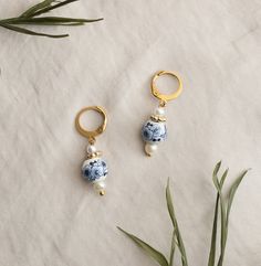 These dainty earrings are made with a floral porcelain bead nestled between glass pearls and gold accents. They are a beautiful and subtle addition to enhance any look! Perfect for a Bride's "something blue". I put a lot of love and thought into every piece I make :) Your product may vary slightly from the photos due to natural variations in the pearls or other handmade aspects of the item, but rest assured that you will be getting something beautiful! This comes packaged in a jewelry pouch, but Blue Porcelain Jewelry, Porcelain Jewelry Handmade, October Jewelry, Porcelain Earrings, Party Earrings, Porcelain Jewelry, Jewelry Essentials, Fancy Jewellery, Dainty Earrings