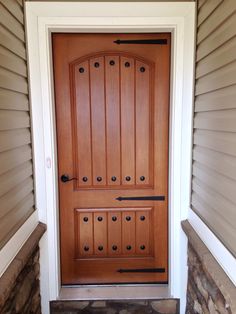 the front door is made of wood and has many knobs on it's sides