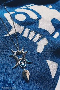 a close up of a necklace on a blue shirt