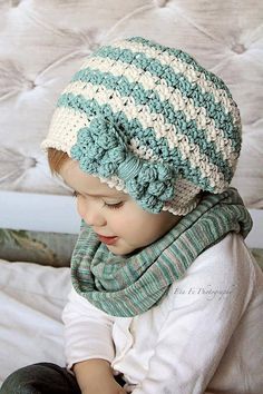 a small child wearing a knitted hat and scarf