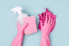 hands in pink gloves with cleaning products on blue background