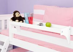 a stuffed monkey sitting on top of a white bunk bed with pink sheets and pillows