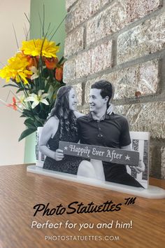 a couple sitting next to each other on a table with flowers in front of them