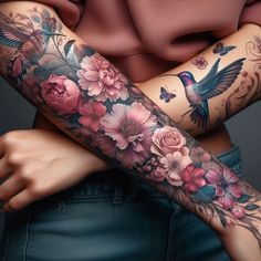 a woman's arm covered in tattoos with flowers and birds on the arm,