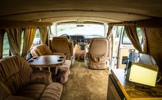 the inside of an rv with couches, tables and television in it's center