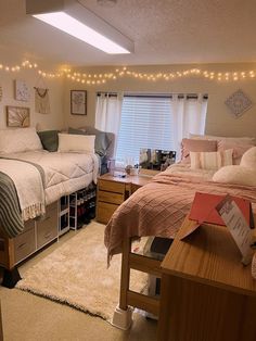 two beds in a dorm room with lights on the ceiling