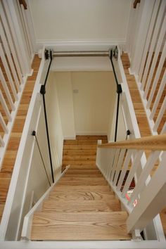 the stairs are made of wood and have white railings