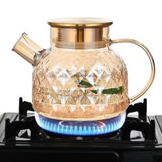 a glass tea pot sitting on top of a gas stove