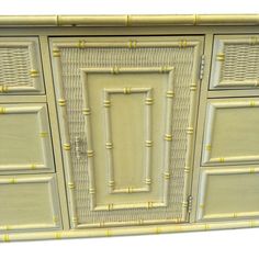 a white cabinet with gold trimmings on the doors and drawers is shown in front of a white background