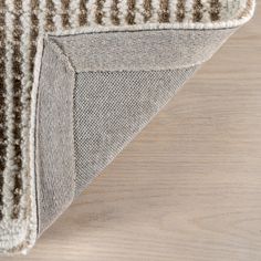 a close up view of the corner of a rug on top of a wooden floor