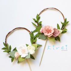 two flower headbands made out of paper flowers and greenery on top of each other