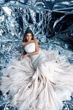 a woman in a white dress sitting on tin foil