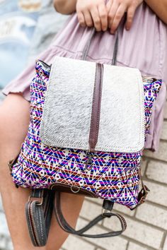 It's festival season baby, and what better bag to take with you on all your fun adventures?! How fun is this vibrant retro print backpack?! We love the print on the front of this one, and how well it pairs with the cowhide! Immediately want to head to a festival in the hills with this one! This bag features a large lobster closure to keep your things secure while you get wild! Under the flap you'll also find a zipper closure for extra protection. Aside from the large opening, there are two separ Multicolor Leather Backpack For Travel, Fun Travel Backpack With Zipper Closure, Fun Travel Shoulder Bag With Adjustable Strap, Multicolor Leather Backpack With Adjustable Strap For Everyday Use, Multicolor Backpack With Adjustable Strap For Festivals, Fun Multicolor Backpack For Travel, Multicolor Leather Backpack With Adjustable Strap For Travel, Bohemian Summer Travel Backpack, Summer Adjustable Backpack