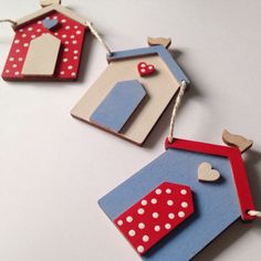 two small wooden houses with hearts hanging from the front and back, each decorated in different colors