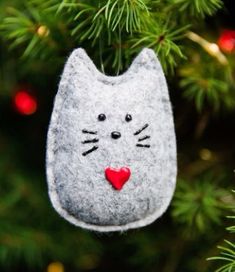 a felt cat ornament hanging from a christmas tree