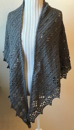 a gray crocheted shawl on a mannequin