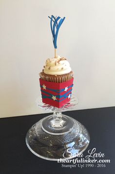 a cupcake with white frosting and red, white and blue decorations on top