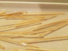 several wooden skewers are in a white bowl