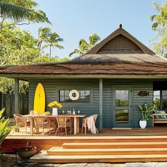 a house with a surfboard sitting on the porch next to it's deck