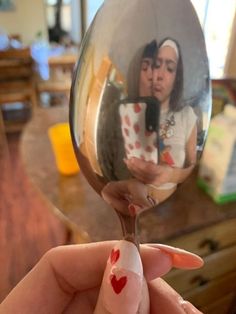 a woman holding a wine glass with her reflection in it