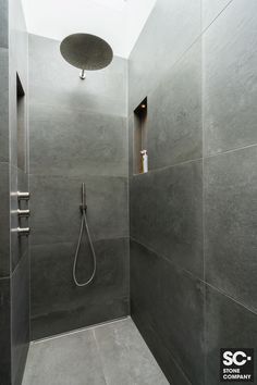 a walk in shower sitting inside of a bathroom next to a skylight above it