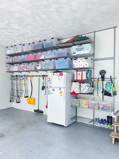 an organized garage with shelves, bins and other items on the wall for storage