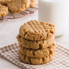 a stack of cookies sitting on top of a table next to a glass of milk