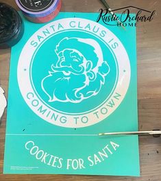 there is a sign that says santa claus coming to town cookies for santa on the table