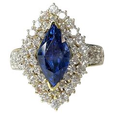 A rare and luxurious vintage blue sapphire ring featuring a vibrant marquise shaped center stone weighing 4.32 carats surrounded by 1.47 carats of sparkling white diamonds set in solid 14k yellow gold. *Approximate stone measurements: Height: 13mm Width: 6mm Approximate ring weight: 8.15 grams Luxury Marquise Sapphire Diamond Ring, Luxury Marquise Cut Blue Sapphire Ring, Luxury Sapphire Ring With Marquise Diamond, Marquise Rings, Vintage Blue Sapphire Ring, Blue Sapphire Diamond Ring, Marquise Ring, Blue Sapphire Ring, Blue Sapphire Diamond