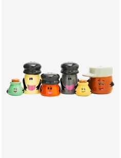 a group of small ceramic pots with faces painted on the sides and one wearing a hat