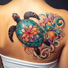 the back of a woman's shoulder with a colorful turtle and flowers on it