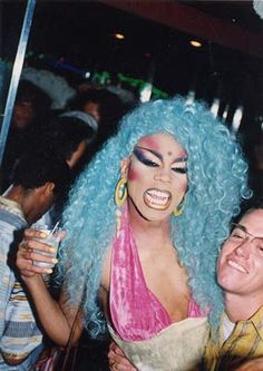 two people with blue hair and makeup posing for a photo together at a club or bar