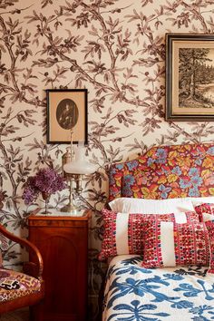 an instagram photo of a bed with floral wallpaper and pillows on the headboard