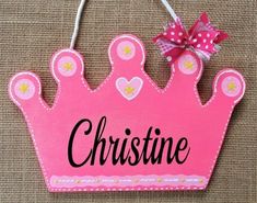 a pink wooden sign with a crown on it that says,'crissine '