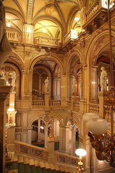 the interior of an ornate building with chandeliers