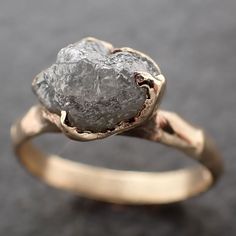 a gold ring with a rough diamond in it