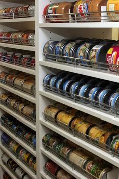 the shelves are filled with various types of cans and tins, all stacked on top of each other