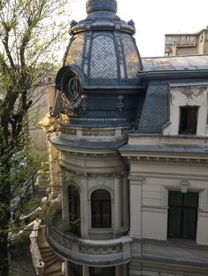 an old building with a clock on the top of it's roof and windows