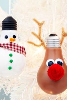 two christmas ornaments hanging from a tree with snowman and reindeer noses on them,