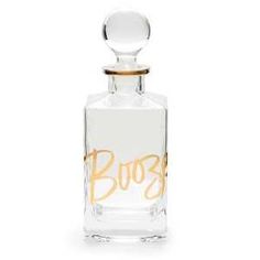 an empty bottle with the word boos written in gold ink on it, sitting on a white surface