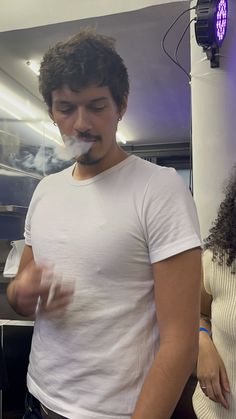 a man standing in front of a woman with a fake moustache on his face