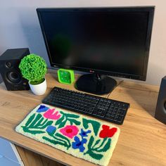 a computer monitor, keyboard and mouse on a desk with a potted broccoli