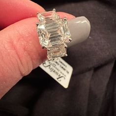 a person holding an engagement ring in their left hand with a price tag on it