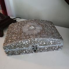 a silver purse sitting on top of a white table