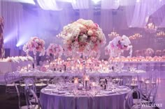 the tables are set with flowers and candles for an elegant wedding reception in purple hues